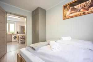 1 Schlafzimmer mit 2 weißen Betten und einer Küche in der Unterkunft Apartament Habel, MyWeek in Bystrzyca Kłodzka
