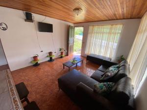 a living room with a couch and a tv at Twin Palms Lodge in Monteverde Costa Rica