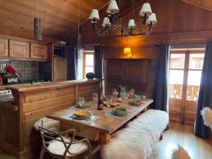 a kitchen with a wooden table with two chairs and a dining room at l’escalade 3 in Courchevel