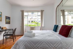 1 dormitorio con 1 cama blanca grande y escritorio en Unhotel - Maravilhoso Apartamento Por Temporada em Copacabana, Perto da Praia, en Río de Janeiro