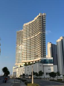 een hoog gebouw met een palmboom ervoor bij Large size one bedroom apartment with sea view in Abu Dhabi