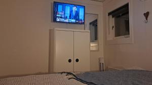1 dormitorio con TV en la parte superior de un armario blanco en Cottage Langan en Strömstad