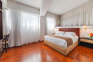 um quarto de hotel com uma cama, uma secretária e uma janela em Suites Teca Once em Cidade do México