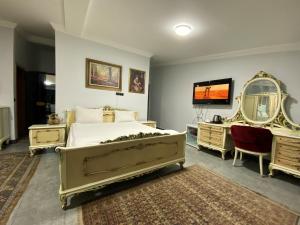 a bedroom with a bed and two mirrors and a television at RZA HOTEL in Aşağı İmrahor