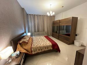 a bedroom with a bed and a television in it at Large size one bedroom apartment with sea view in Abu Dhabi
