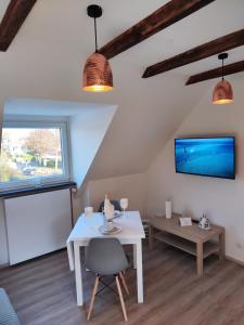 a living room with a white table and a tv at Kleine Perle bei Hamburg in Reinbek