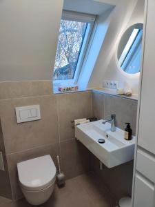 a bathroom with a toilet and a sink and a window at Kleine Perle bei Hamburg in Reinbek