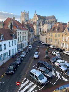 a city street with cars parked in a parking lot at La clef Sithieu in Saint-Omer