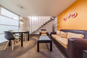 ein Wohnzimmer mit Sofa und Tisch in der Unterkunft Suites Teca Once in Mexiko-Stadt
