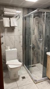 a bathroom with a toilet and a glass shower at RZA HOTEL in Aşağı İmrahor