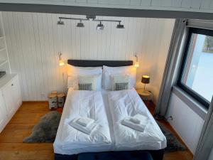 - une chambre avec un lit doté de draps et d'oreillers blancs dans l'établissement Magnifique Maison près du centre, à Nendaz