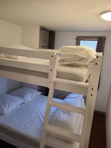 - une chambre avec deux lits superposés et un lit dans l'établissement Appartement Hauteurs Super Besse - 4 personnes -Piscine & Garage, à Besse-et-Saint-Anastaise