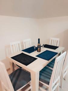 a white table with a bottle of wine on it at Apartmani Mir A3 in Vrnjačka Banja