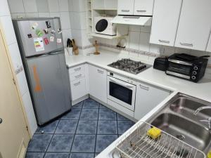 a kitchen with a sink and a refrigerator at Delpino Propiedades Veracruz in Viña del Mar