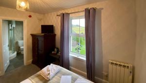 a room with a window and a bed and a bathroom at Troutbeck Inn in Troutbeck