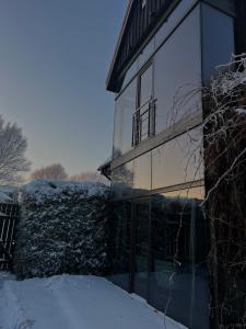 a house with glass doors in the snow at Boutique Guest House in Liepāja