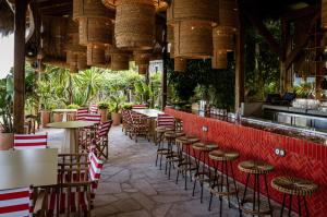 un restaurante con mesas, sillas y plantas en Casa Beatnik Hotel, en Santiago de Compostela