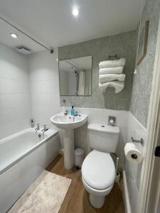 a bathroom with a toilet and a sink and a tub at Cocketts Hotel in Hawes