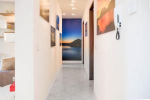 a hallway leading to a bedroom with art on the walls at Fall In Love with Como Lake in Bellano