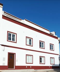 um edifício branco com um telhado vermelho em SulSeixe Guesthouse em Odeceixe