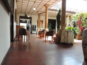 un vestíbulo con sillas y mesas en un edificio en Hotel Real en Ocaña