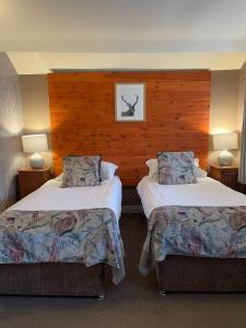 um quarto de hotel com duas camas e duas lâmpadas em Cocketts Hotel em Hawes