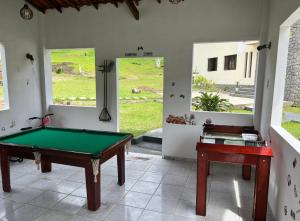 Habitación con mesa de billar y 2 ventanas en Chalé em Pousada Recanto MD, en Itaboraí