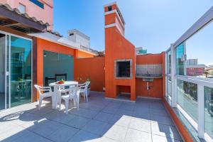 a balcony with a table and chairs on a building at Espaçosa Cobertura Duplex com Piscina Privativa in Bombas