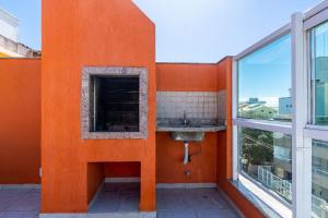 an orange wall with a sink and a window at Espaçosa Cobertura Duplex com Piscina Privativa in Bombas