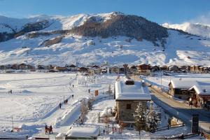 una città nella neve con una montagna sullo sfondo di Hotel Bondi a Livigno