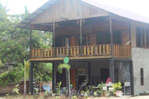 een groot huis met een terras erop bij Air Manis Secret Surfcamp in Taluk Batung