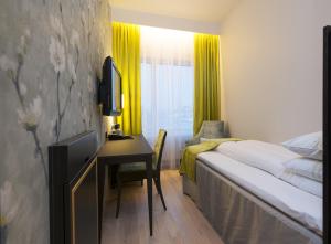 a hotel room with a bed and a desk and a window at Thon Hotel Opera in Oslo