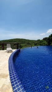 a chair sitting next to a swimming pool at Villas do Pratagy Maceió in Maceió