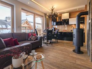 a living room with a couch and a kitchen at VisitZakopane - Dolomite SPA Apartment in Zakopane