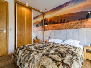 a bedroom with a large bed with a large animal blanket at VisitZakopane - Dolomite SPA Apartment in Zakopane