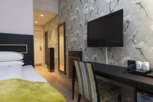 a hotel room with a bed and a flat screen tv at Thon Hotel Opera in Oslo