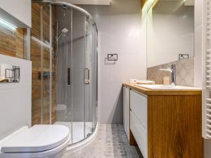 a bathroom with a shower and a toilet and a sink at VisitZakopane - Dolomite SPA Apartment in Zakopane +19 photos