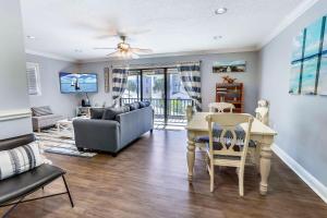 ein Wohnzimmer mit einem Tisch und einem Sofa in der Unterkunft Sea Shell 14 - Premier in Clearwater Beach