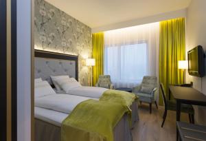 a hotel room with a large bed and a desk at Thon Hotel Opera in Oslo
