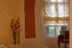 Habitación con ventana y jarrón con flores en Room in Faneromeni's grove en Kastoria