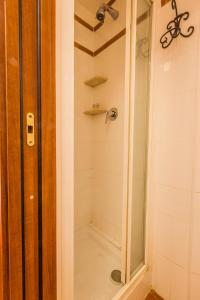 een douche met een glazen deur in de badkamer bij Hotel 4 Coronati in Rome