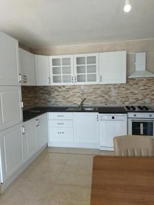 a white kitchen with white cabinets and a sink at Ferienhaus mit Meerblick in Bodrum City