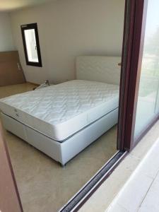 a large bed in a room with a window at Ferienhaus mit Meerblick in Bodrum City