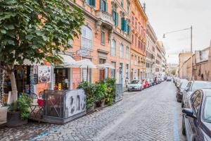 una calle adoquinada con edificios y coches aparcados en Hotel 4 Coronati, en Roma
