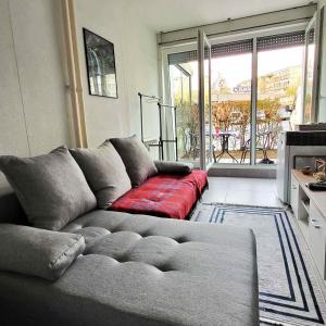 a living room with a couch with a red blanket at Hana’s Apartment in Pristina