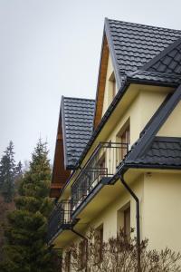 a house with two balconies and a black roof at Budzowie in Białka Tatrzańska