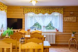 een eetkamer met een tafel en stoelen en een raam bij Leśna Ostoya in Białka Tatrzanska