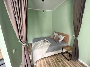 a small bed in a room with curtains at SN Apartments in Osh