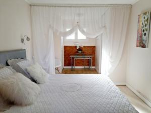 タラスコン・シュル・アリエージュにあるLes gîtes du clos des pradalsのベッドルーム(大きな白いベッド1台、窓付)