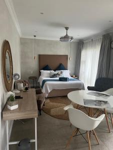 a bedroom with a bed and a table and chairs at Annie's Place in Kempton Park